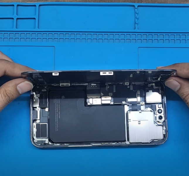 an iPhone being opened for a screen repair internal parts are seen like the battery camera and other parts