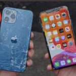 person holding a cracked iphone