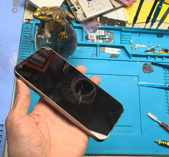 tech expret holding a broken google pixel phone next to workstation
